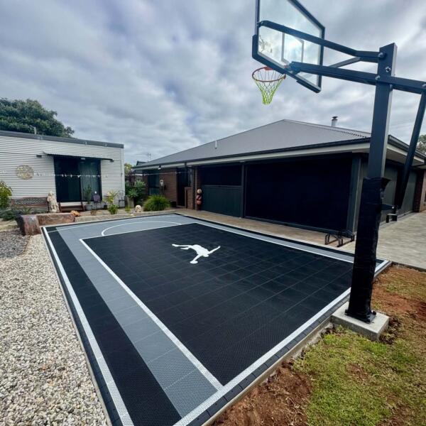 Finished backyard basketball court in Swan Hill with glow in the dark lines and Slam Man logo