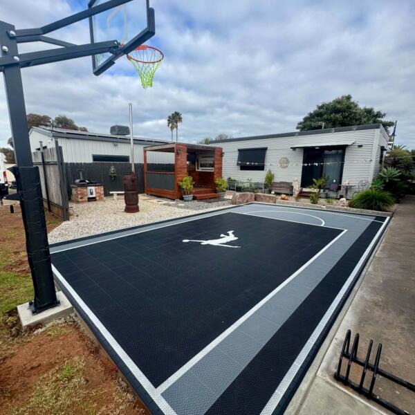 Finished backyard basketball court in Swan Hill with glow in the dark lines and Slam Man logo