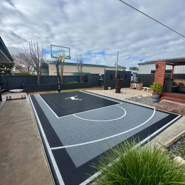 Finished backyard basketball court in Swan Hill with glow in the dark lines and Slam Man logo