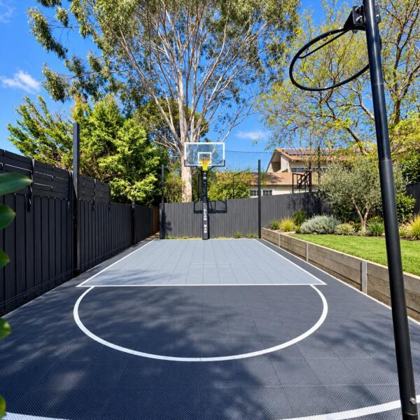 Finished 5m x 9m Slam Man Elite backyard basketball court in Rosanna with light grey key and dark grey outer tiles
