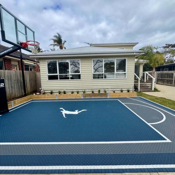 Slam Man Pro Cushion backyard basketball court in Ocean Grove with charcoal blue key and dark grey outer